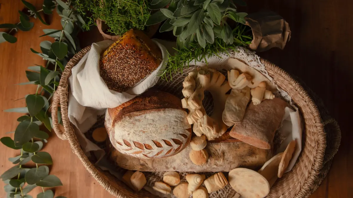 Mand met verse zuurdesembroden en gebak