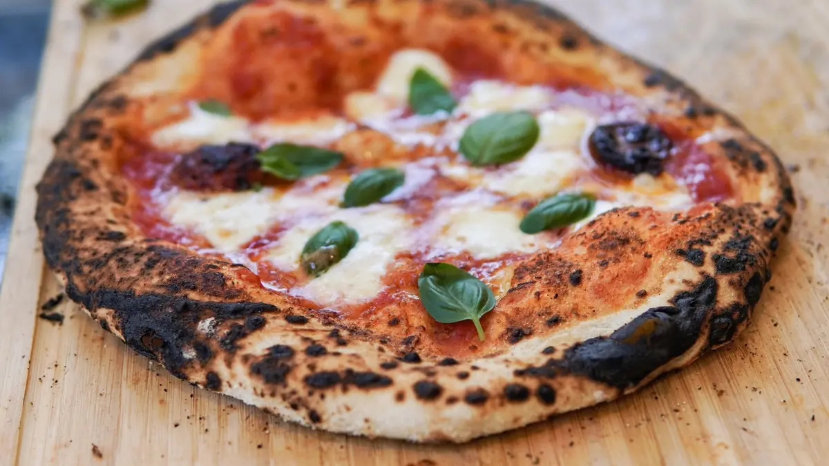 Napolitaanse pizza met een goed gepofte, donker gevlekte cornicione