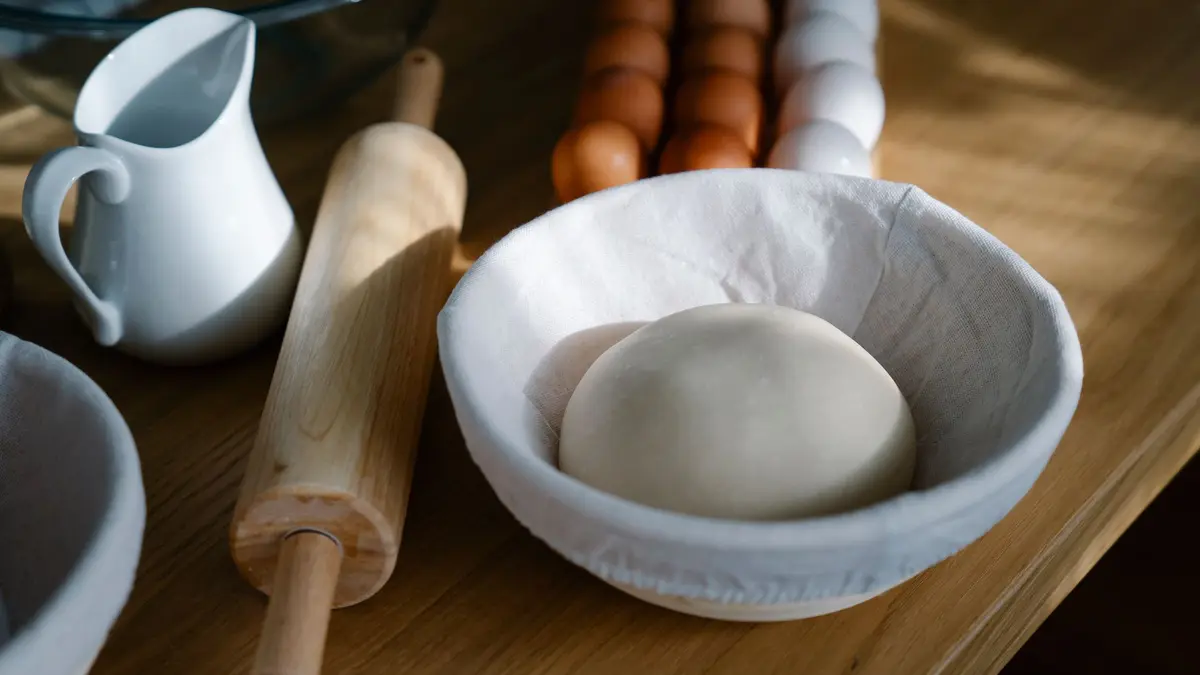 Deeg rustend in een kom op een houten werkblad